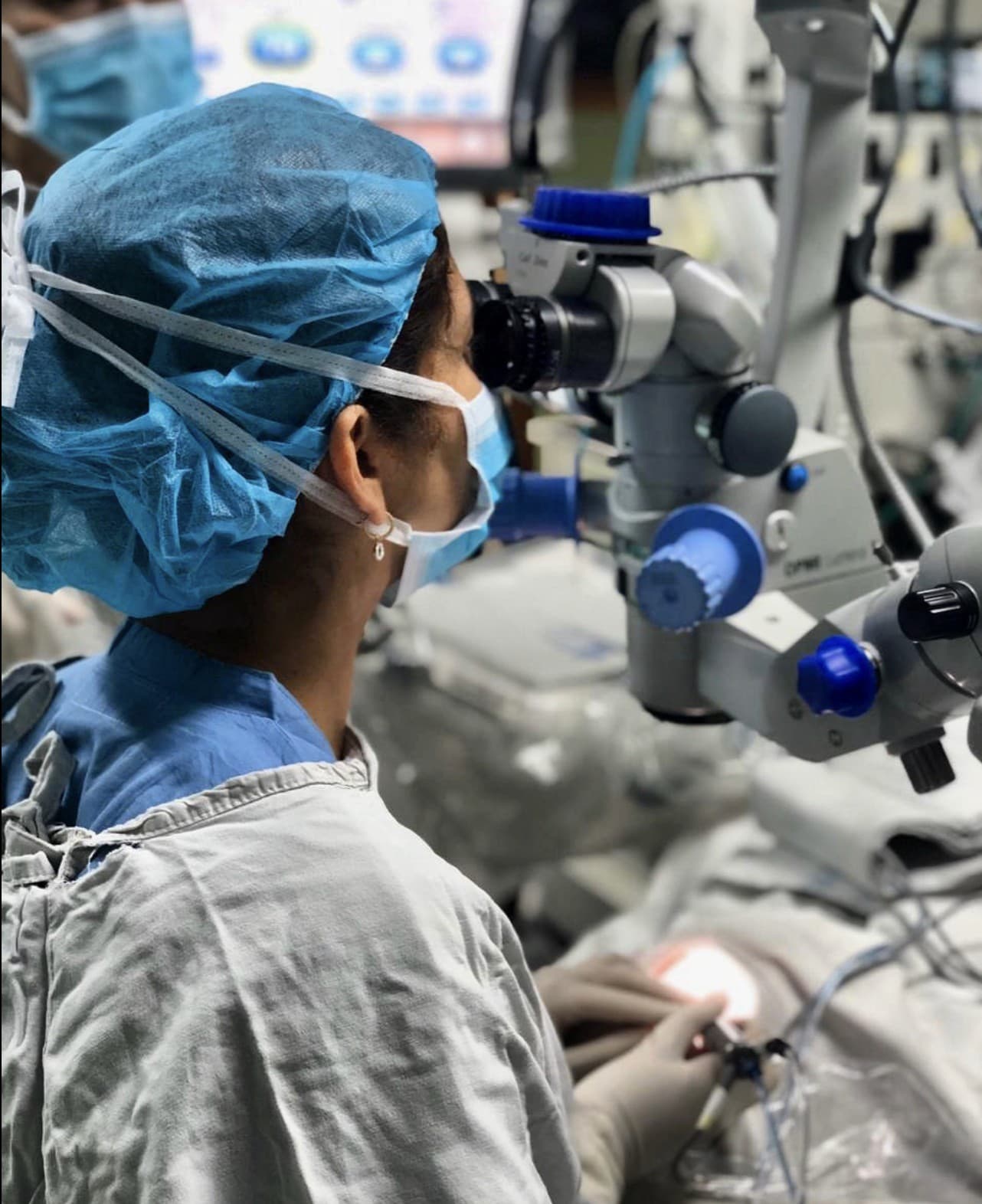 Dra. Andrea Laiton operando con el microscopio quirúrgico